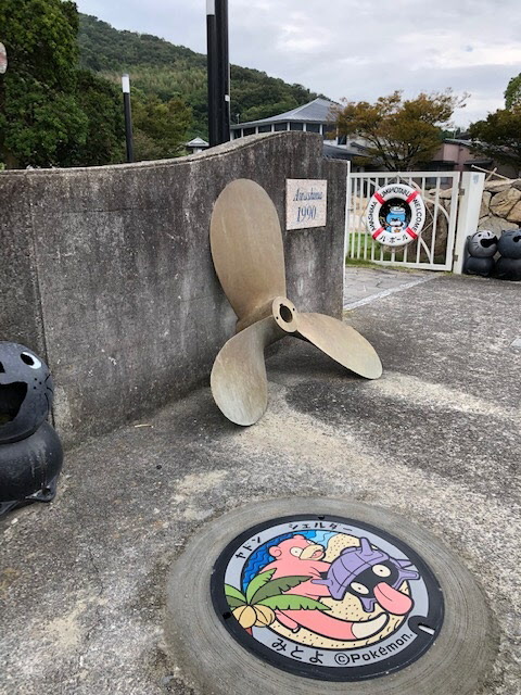 プロペラのオブジェと門の手前に設置された、粟島のヤドンとシェルダーのポケふた