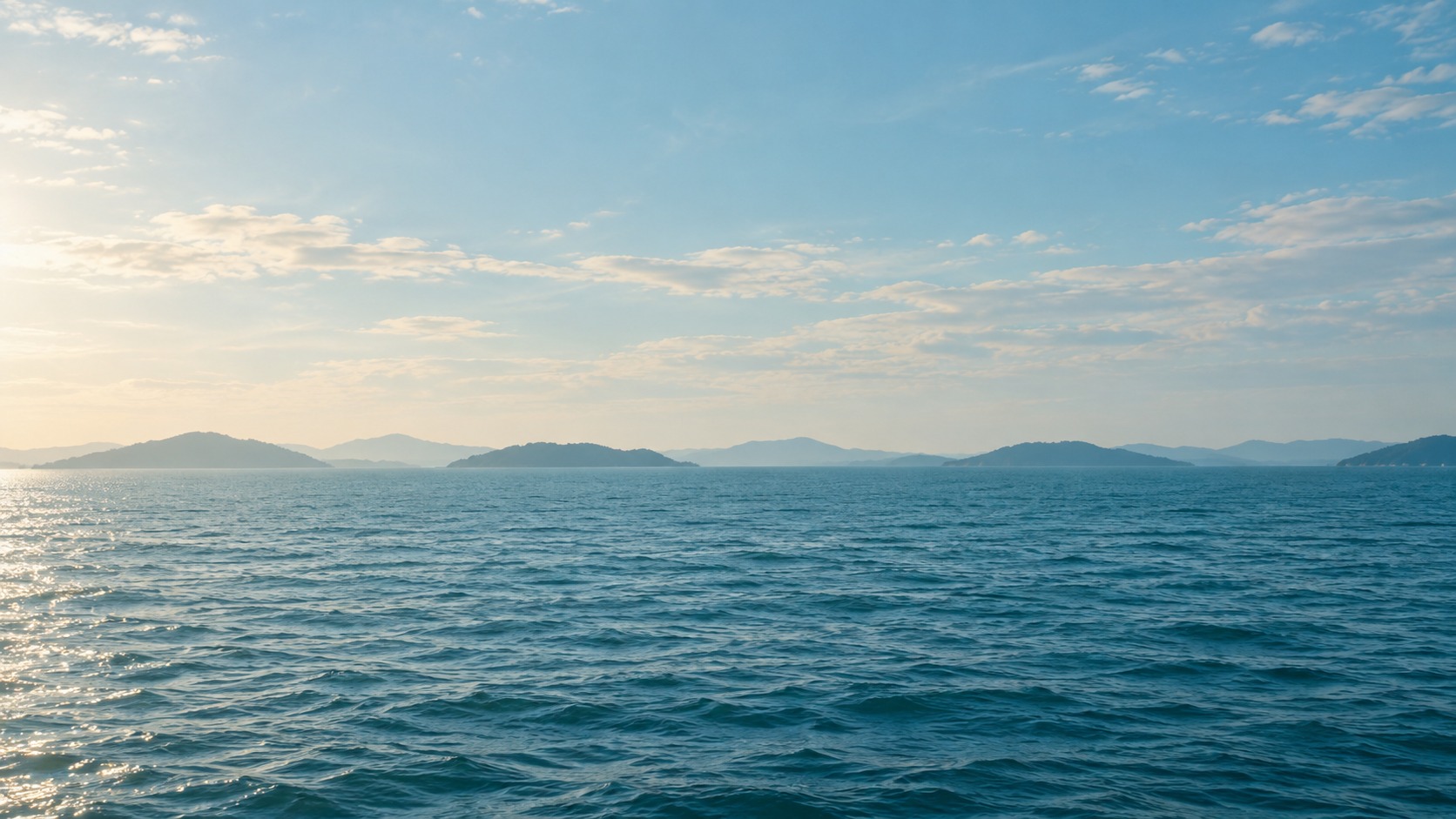 穏やかな海と遠くに浮かぶ島々。瀬戸内の船旅を表現したイメージ
