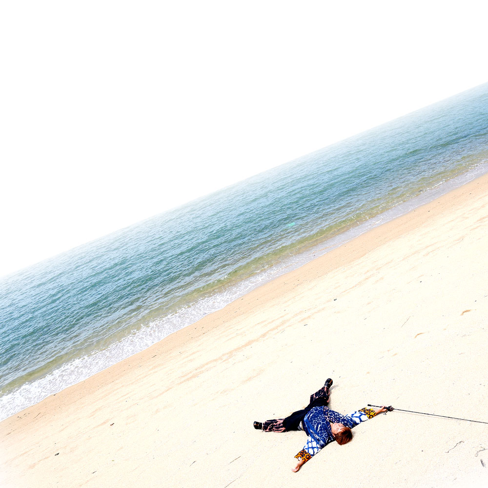 海辺に寝そべる人物